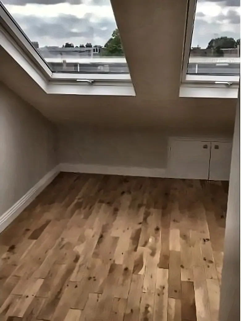 The finished loft room with roof windows, plastered walls and new flooring