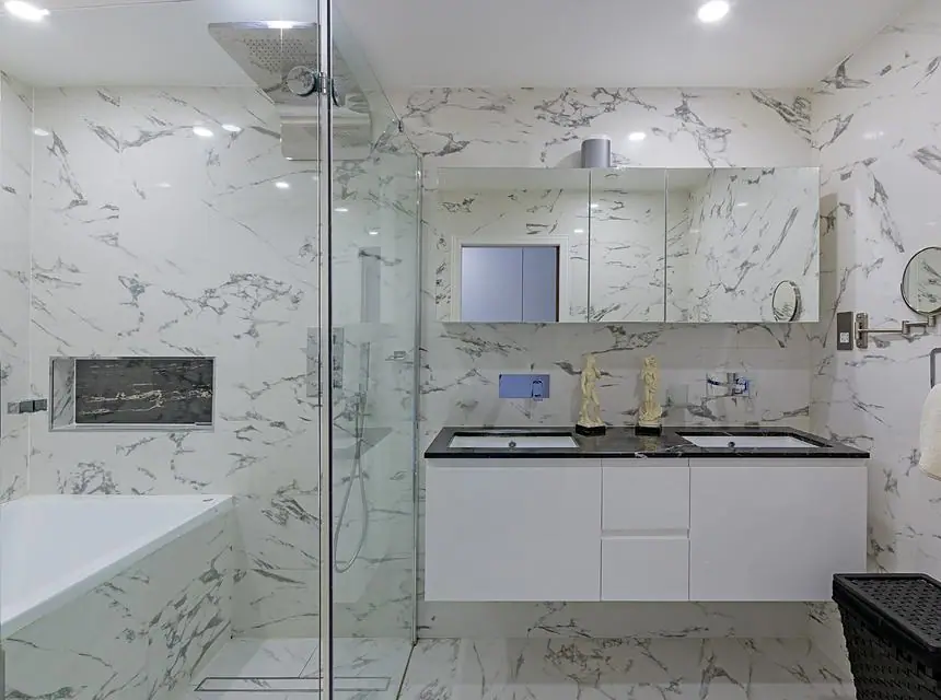 A finished marble bathroom with walk-in shower